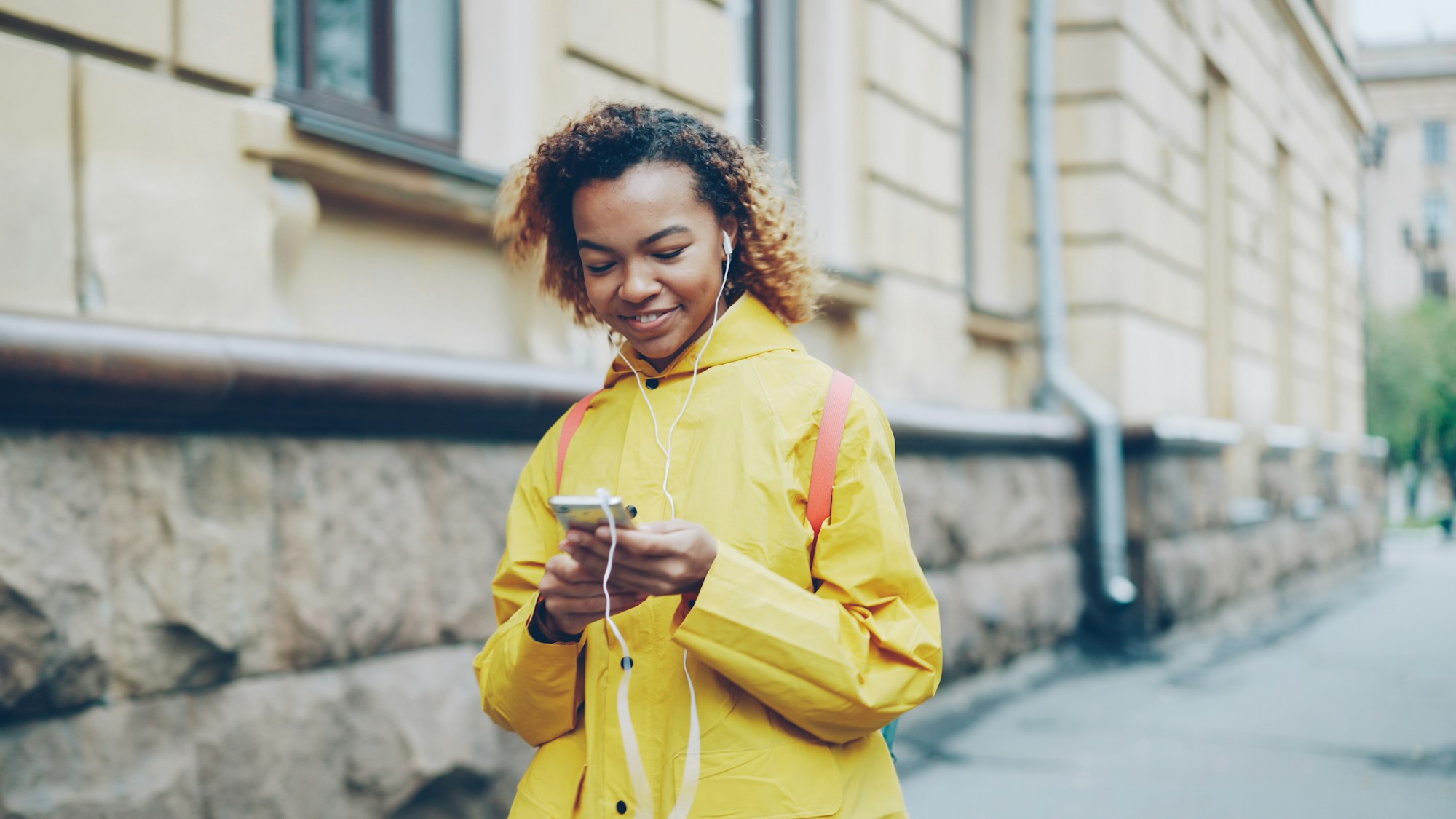 A woman smiling as she reads a payment message on her phone