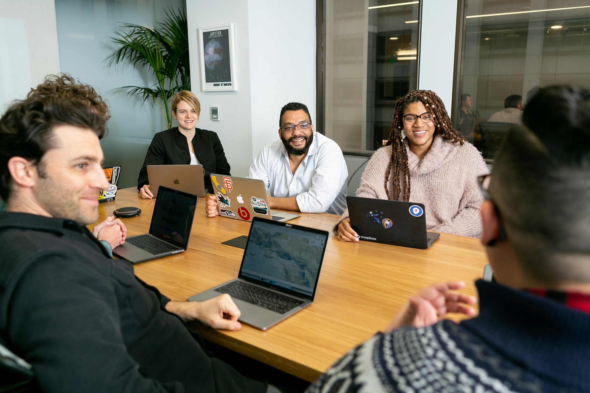 A finance team reviewing a payout batch together on laptops